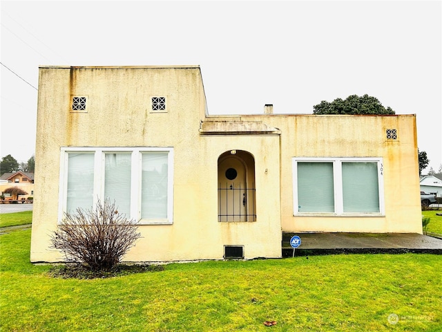 rear view of property featuring a yard