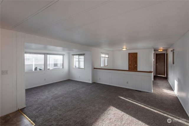 unfurnished living room with dark carpet