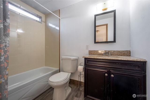 full bathroom featuring toilet, vanity, wood-type flooring, and tiled shower / bath combo