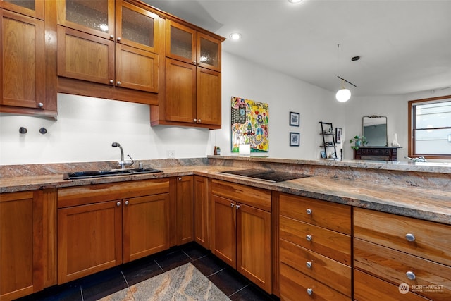 kitchen featuring black electric cooktop, light stone countertops, and sink