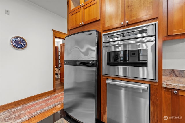 kitchen with light stone countertops and appliances with stainless steel finishes