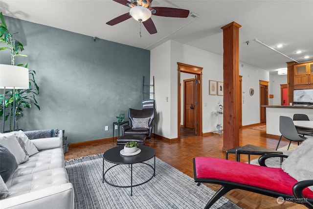 living room with ceiling fan, dark parquet flooring, and ornate columns