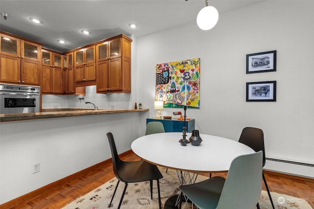 dining room with dark parquet floors, sink, and a baseboard radiator