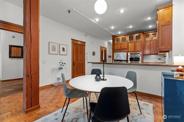 dining area featuring sink and light parquet flooring