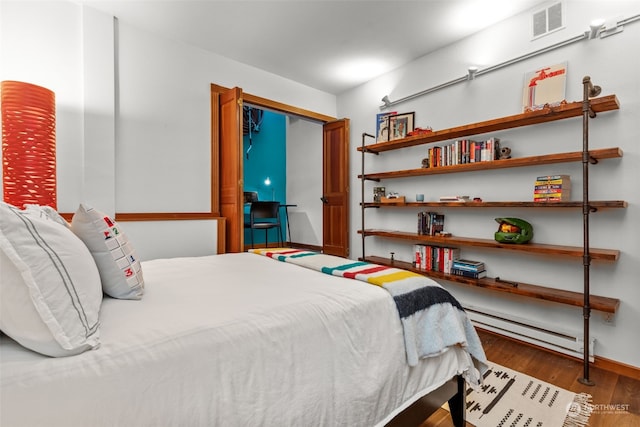 bedroom featuring a baseboard radiator and dark wood-type flooring