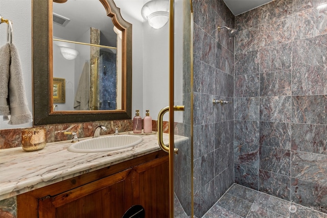 bathroom with vanity and tiled shower