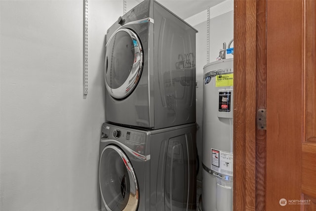 laundry room featuring water heater and stacked washer and clothes dryer