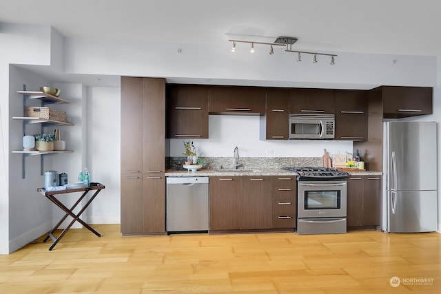 kitchen featuring light wood-type flooring, stainless steel appliances, and sink