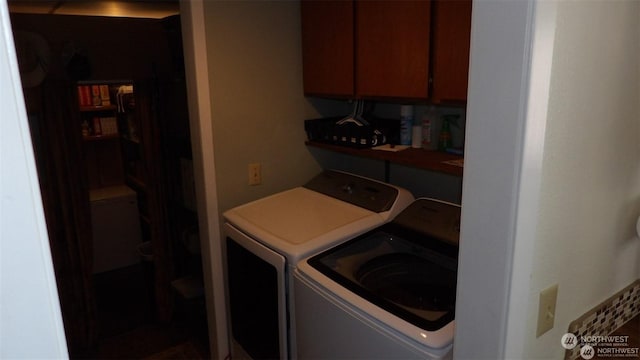 clothes washing area with cabinets and separate washer and dryer