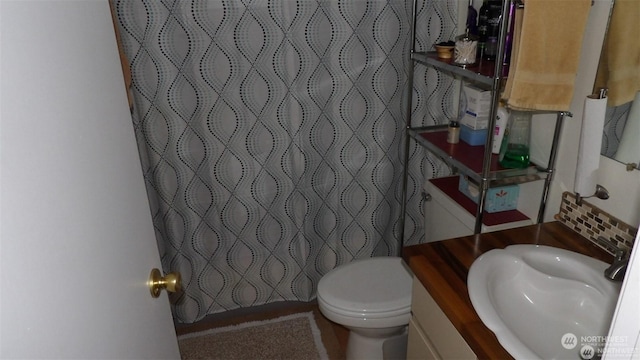 bathroom featuring a shower with curtain, vanity, and toilet