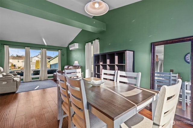 dining space featuring hardwood / wood-style floors, lofted ceiling, and a wall mounted AC