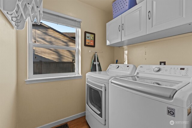 laundry room with cabinets, dark hardwood / wood-style floors, and washer and dryer