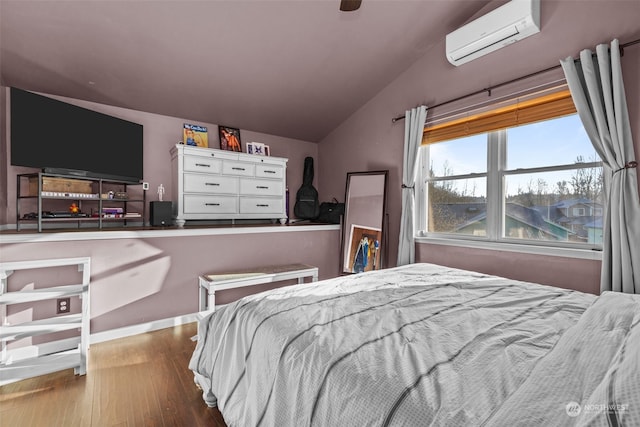 bedroom with hardwood / wood-style flooring, vaulted ceiling, a wall unit AC, and ceiling fan