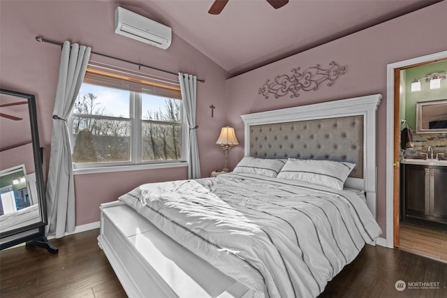 bedroom with an AC wall unit, lofted ceiling, ceiling fan, dark wood-type flooring, and ensuite bath