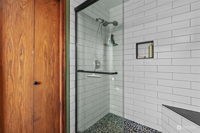 bathroom featuring a shower with shower door