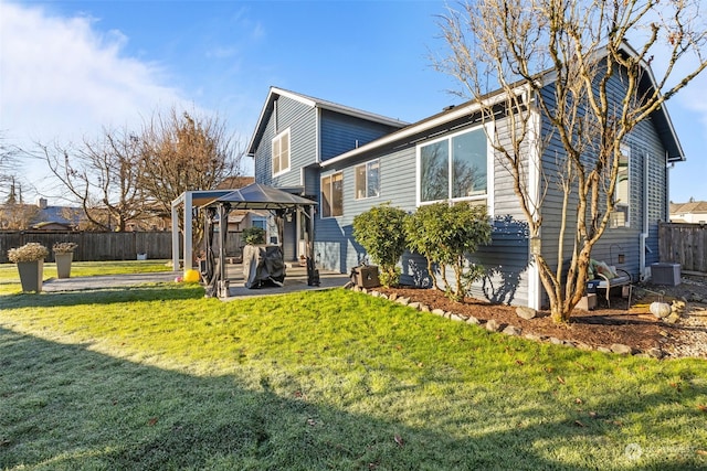 rear view of house featuring a gazebo, central AC, a patio area, and a lawn