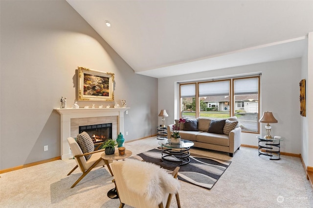 carpeted living room featuring a tile fireplace and vaulted ceiling