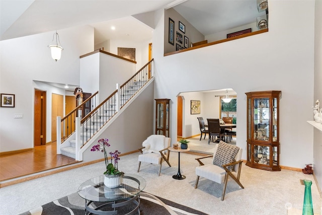 carpeted living room featuring a high ceiling