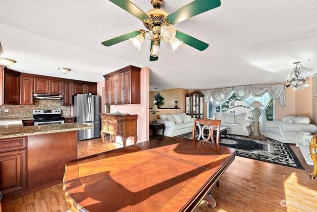 dining room with a textured ceiling, light hardwood / wood-style flooring, a notable chandelier, and sink