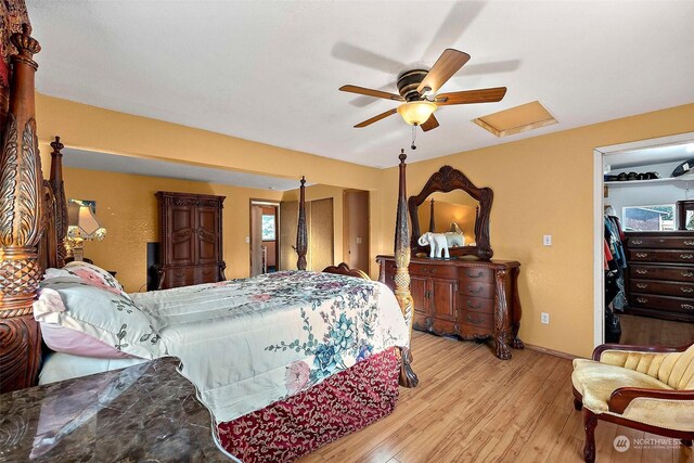 bedroom with ceiling fan, a closet, a spacious closet, and light hardwood / wood-style floors