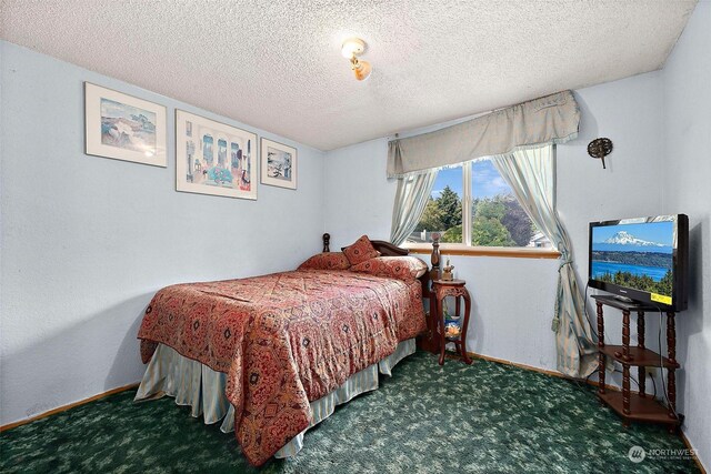 bedroom with dark carpet and a textured ceiling