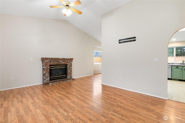 unfurnished living room with a fireplace, light hardwood / wood-style flooring, ceiling fan, and lofted ceiling