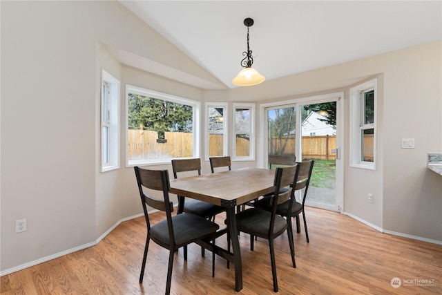 dining area featuring light wood-type flooring and lofted ceiling