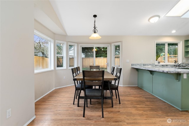 dining area featuring a skylight, hardwood / wood-style floors, and sink