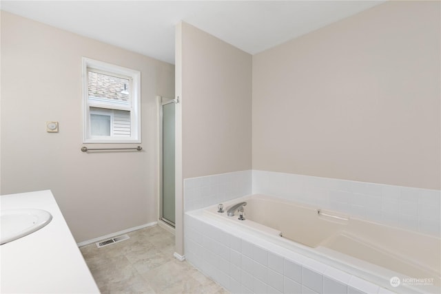 bathroom with vanity and shower with separate bathtub