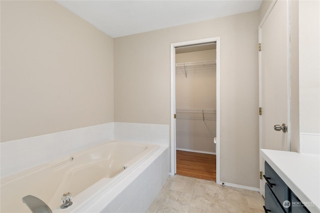 bathroom featuring vanity and tiled bath