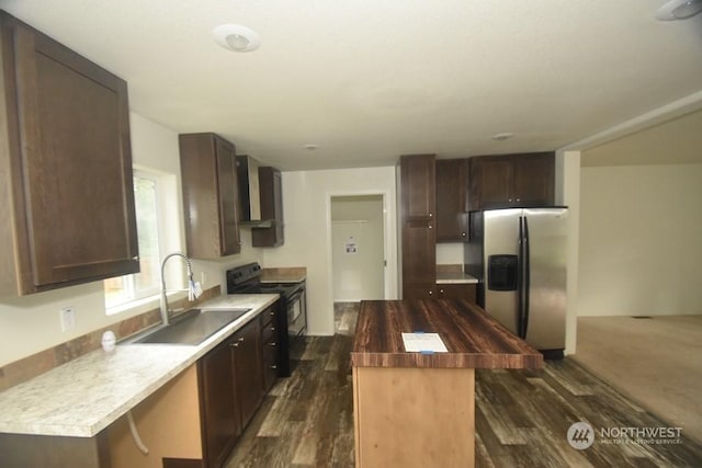 kitchen featuring stainless steel refrigerator with ice dispenser, wall chimney exhaust hood, black electric range oven, sink, and a kitchen island