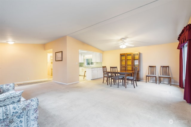 carpeted dining area featuring ceiling fan and vaulted ceiling