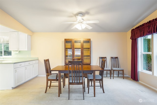 dining space featuring ceiling fan and light carpet