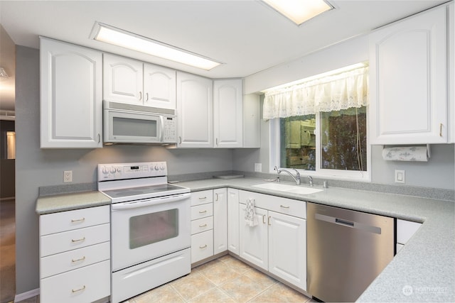 kitchen with white cabinets, light tile patterned floors, white appliances, and sink