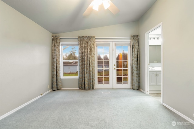 spare room with ceiling fan, french doors, light colored carpet, and lofted ceiling