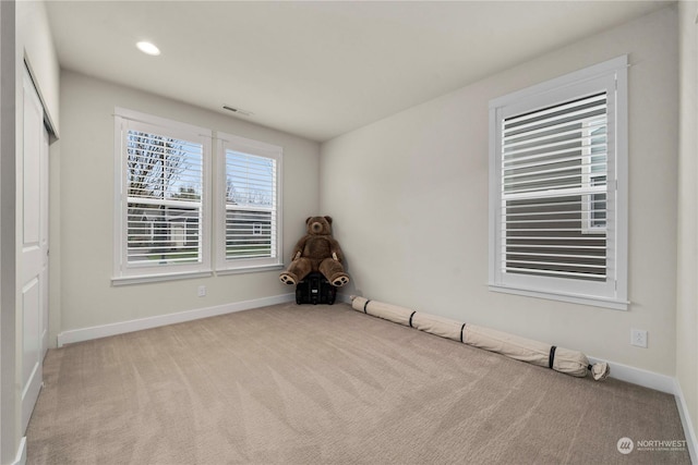 spare room featuring light colored carpet