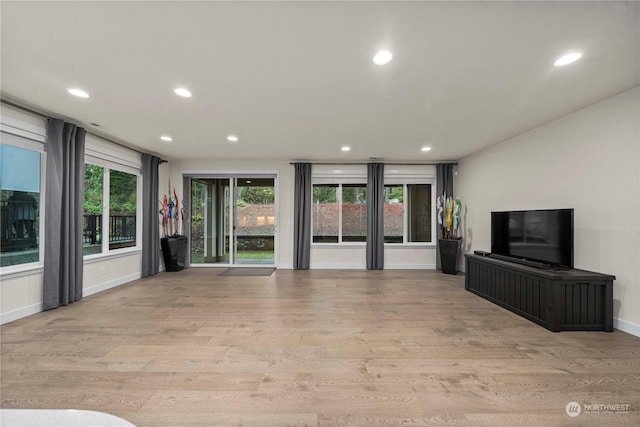 unfurnished living room with a healthy amount of sunlight and light wood-type flooring