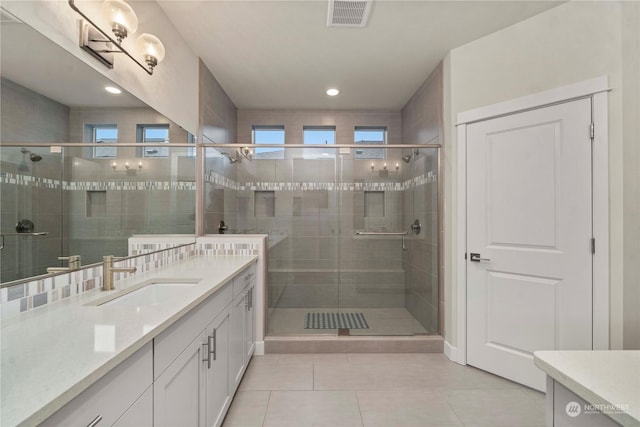 bathroom with tile patterned flooring, vanity, and walk in shower