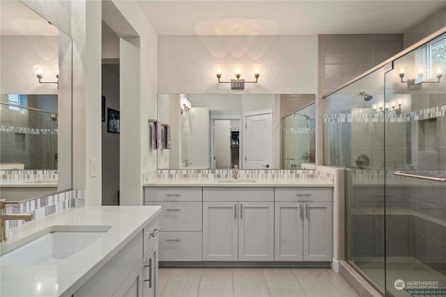 bathroom with tile patterned flooring, vanity, and walk in shower