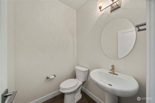 bathroom with hardwood / wood-style flooring, toilet, and sink