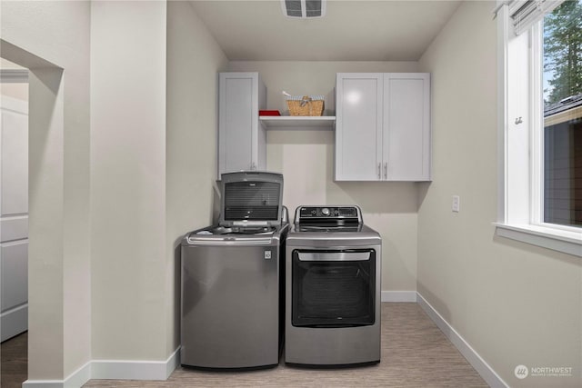 laundry area with washer and dryer and cabinets