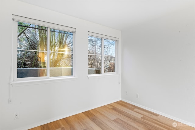 unfurnished room with a healthy amount of sunlight and light hardwood / wood-style flooring