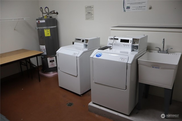 laundry area featuring washing machine and clothes dryer, electric water heater, and sink