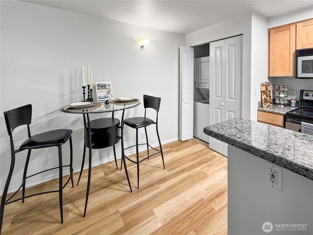 300 10th Ave Unit B-105, Seattle, WA 98122 - dining room featuring stacked washer and clothes dryer, light wood finished floors, and baseboards