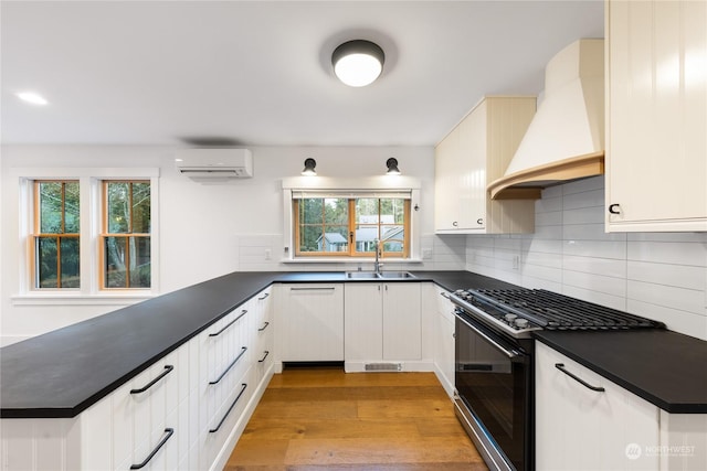 kitchen featuring stainless steel gas range oven, white cabinets, white dishwasher, sink, and custom range hood