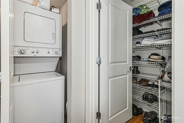 laundry area featuring hardwood / wood-style flooring and stacked washer and dryer