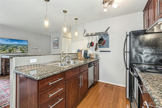 kitchen featuring electric range, hanging light fixtures, dark stone counters, sink, and stainless steel dishwasher