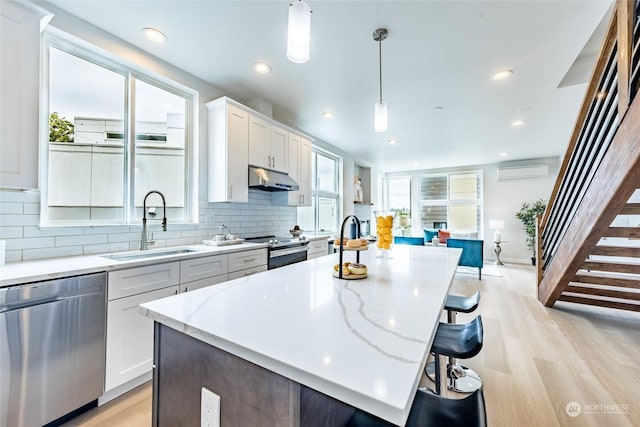 kitchen featuring pendant lighting, white cabinetry, appliances with stainless steel finishes, and a center island