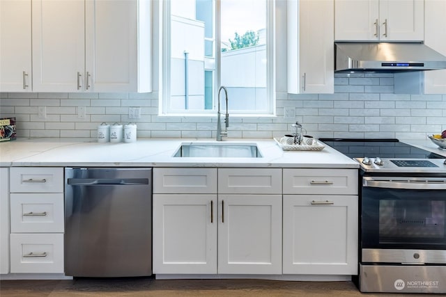 kitchen with appliances with stainless steel finishes, sink, white cabinets, and light stone counters