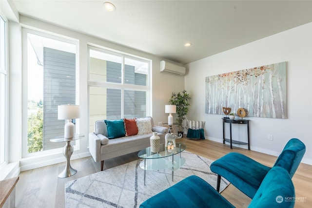 living room with a wall mounted air conditioner and light wood-type flooring